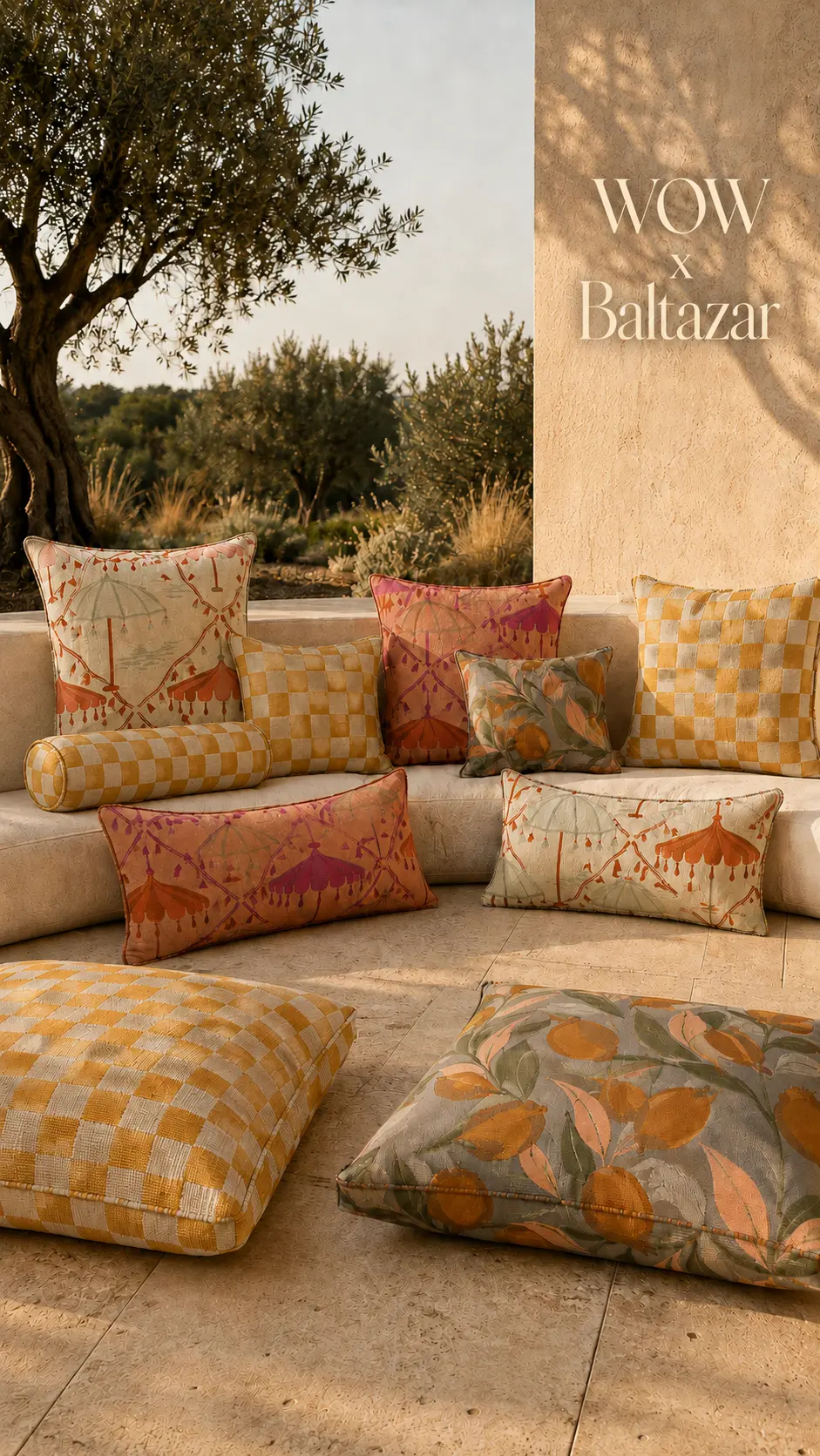 Printed cushions and floor cushions arranged on a stone bench under an olive tree